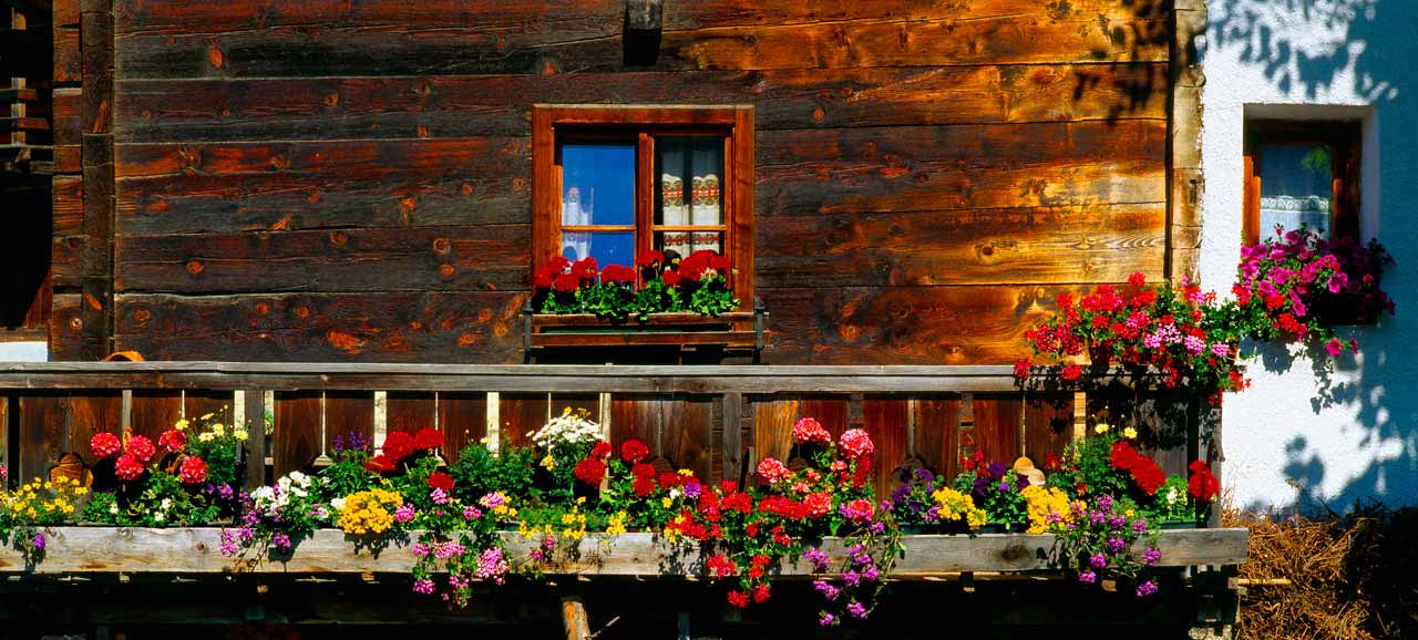 Balcone di legno e piante in fiore in Alto Adige