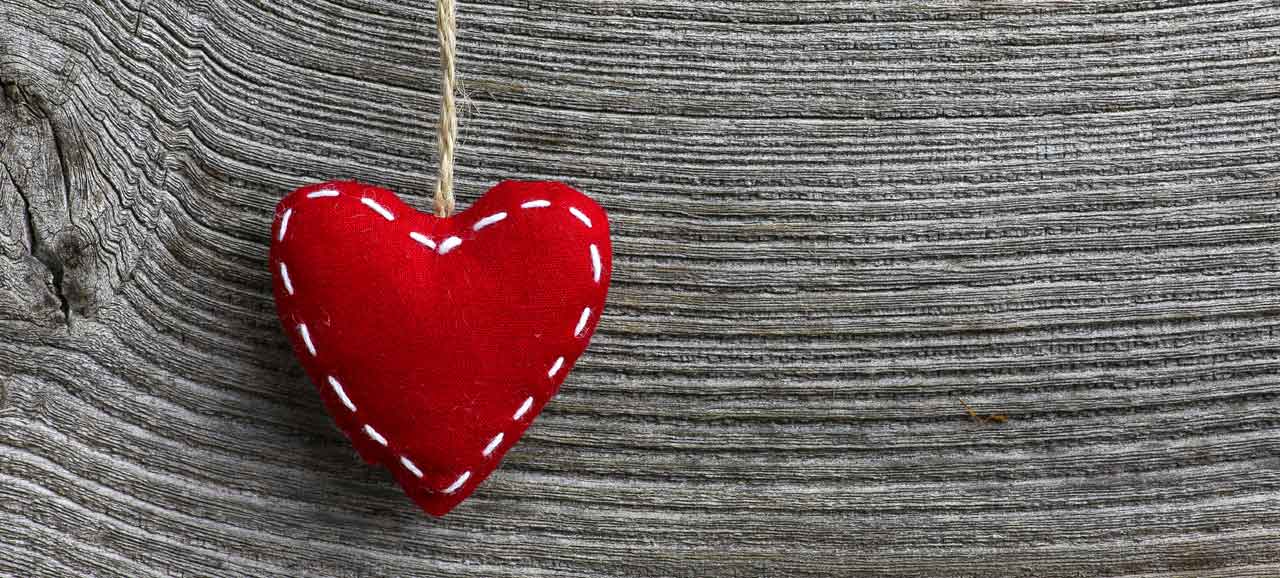 Red felt heart on a wooden panel