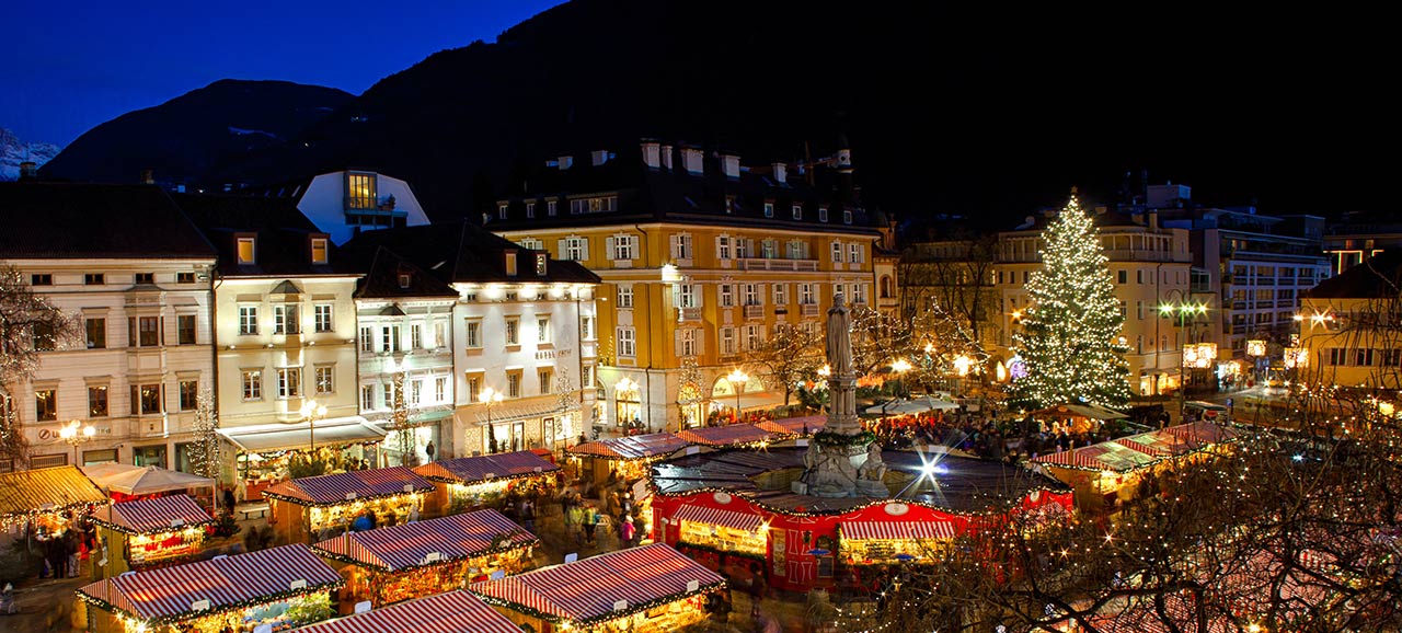 Der Weihnachtsmarkt von Bozen am Abend mit all den beleuchteten Stände und dem leuchtenden Weihnachtsbaum