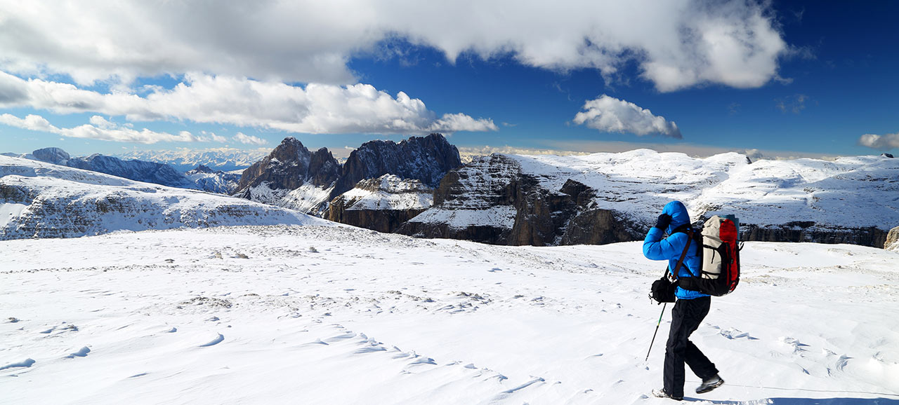 Ein Bergwanderer mit alpiner Ausrüstung auf den schneebedeckten Gipfeln von den Südtiroler Dolomiten