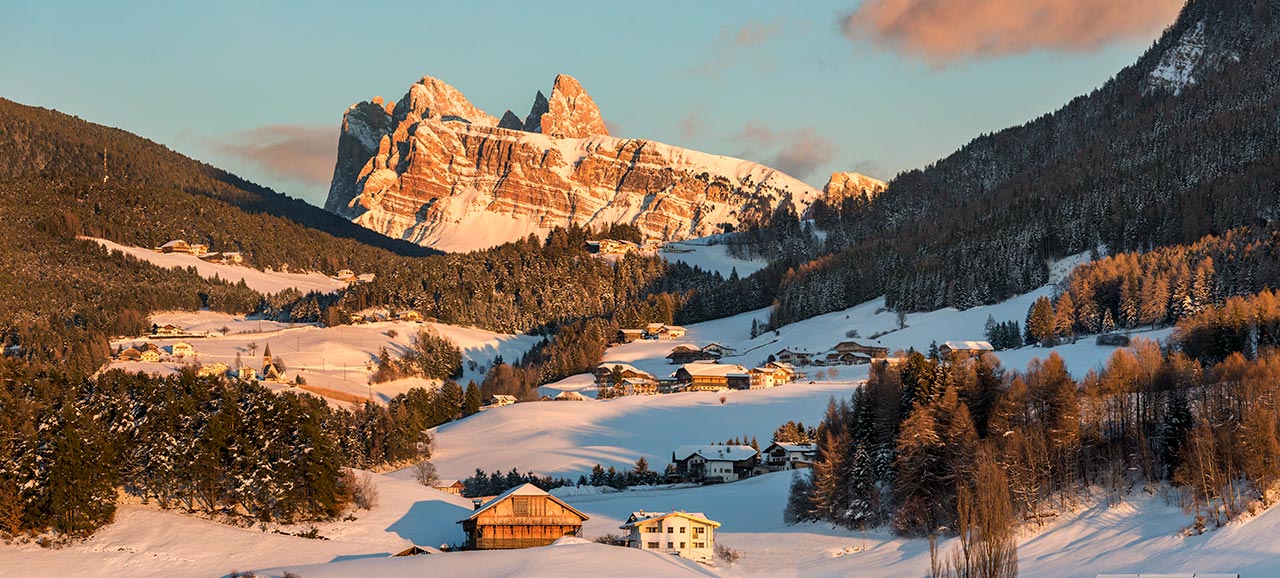 A panoramic image of the South Tyrolean snow-capped mountains at sunset