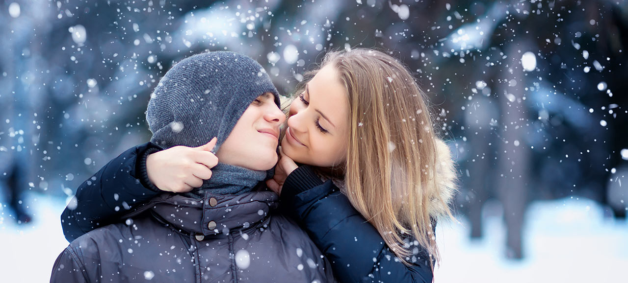 Courting couple in snow caress itself while it's snowing