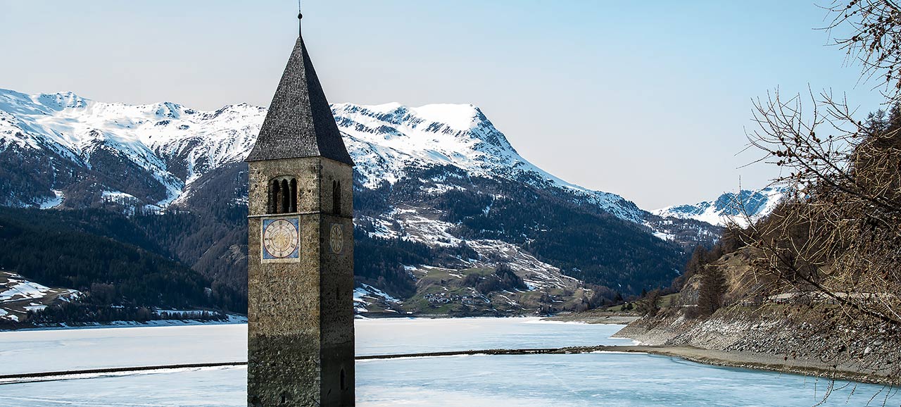 Der gefrorene See von Reschen mit dem Kirchturm der aus dem Wasser ragt