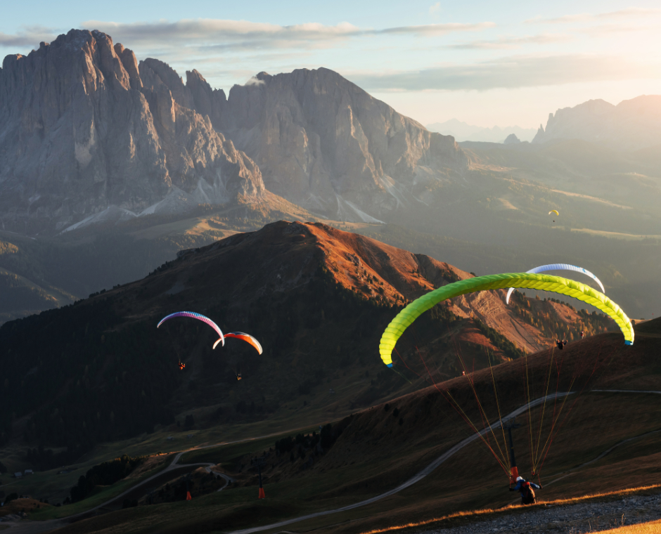 Molti parapendisti sorvolano le Dolomiti di Seceda all'alba.