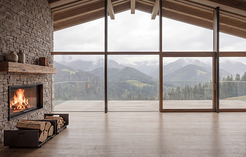 Soggiorno moderno con camino acceso e vista panoramica sulle montagne attraverso grandi vetrate