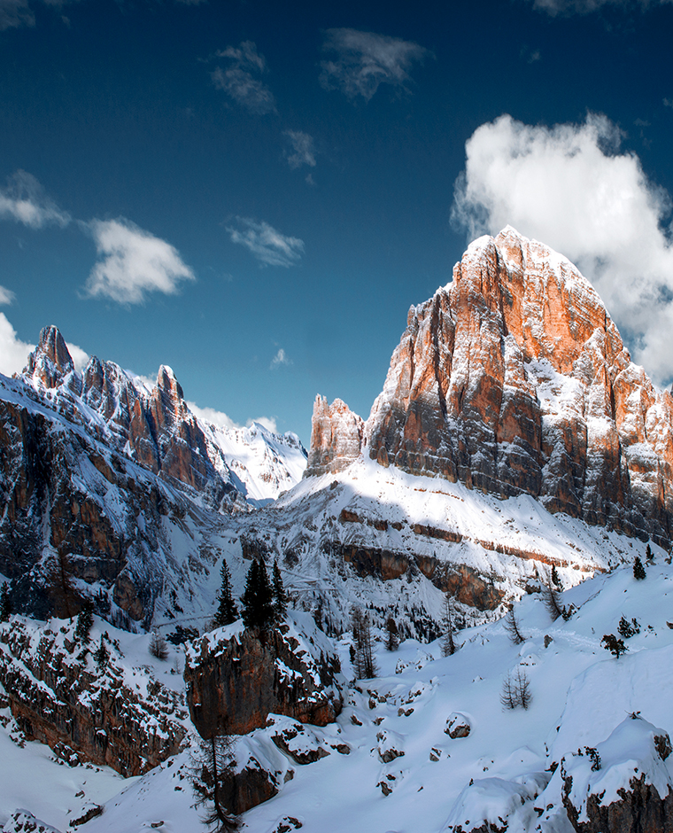Winter landscape of the Dolomites with snow-covered mountains and blue sky