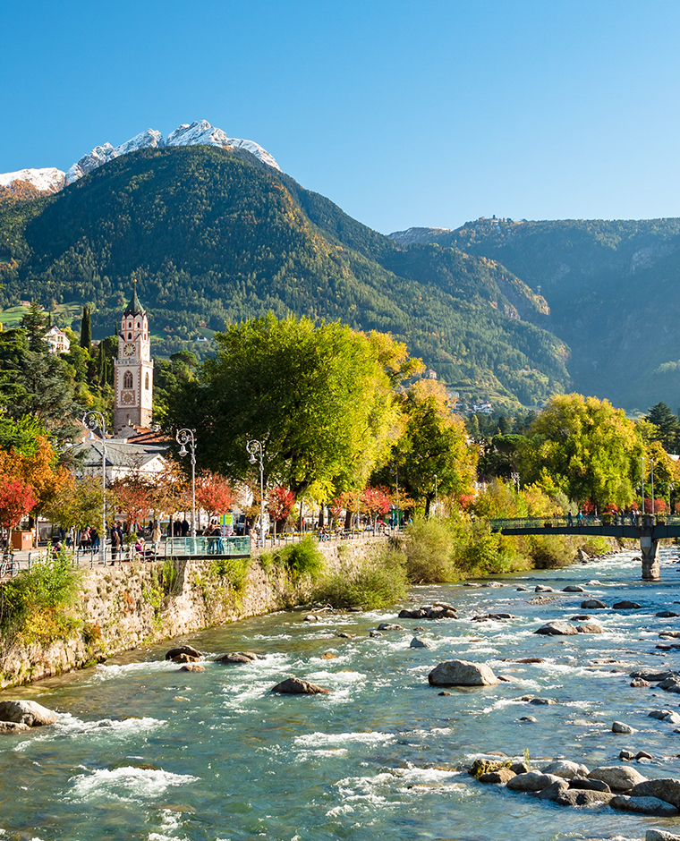 Promenade along the Passer river with view of Merano and surrounding mountains