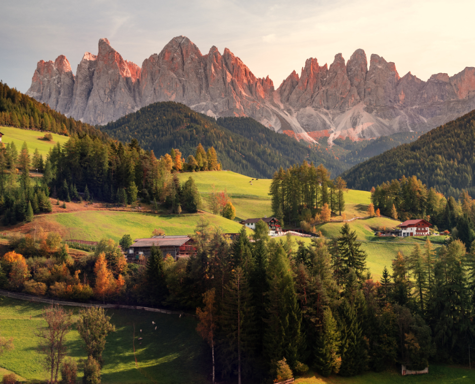  Fotografia aerea di case su un campo verde con vista sulla montagna sotto un cielo bianco e grigio durante il giorno