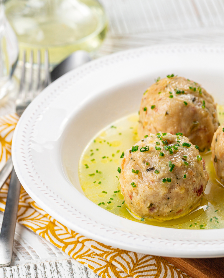 Canederli o Knödel in brodo con cipollotto, pasta o gnocchi tipici della cucina alpina, altoatima, tedesca, italiana e austriaca. Preparati con pane raffermo, latte, uova e speck.