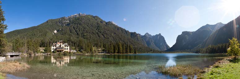 Il lago di Dobbiaco circondato da montagne e alberi