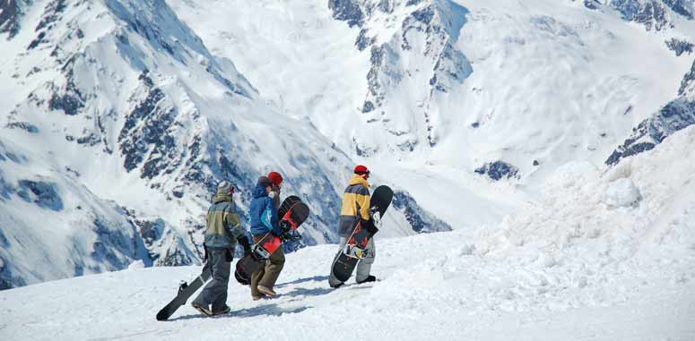 Sportivi che praticano lo snowboard in un paesaggio invernale coperto di neve