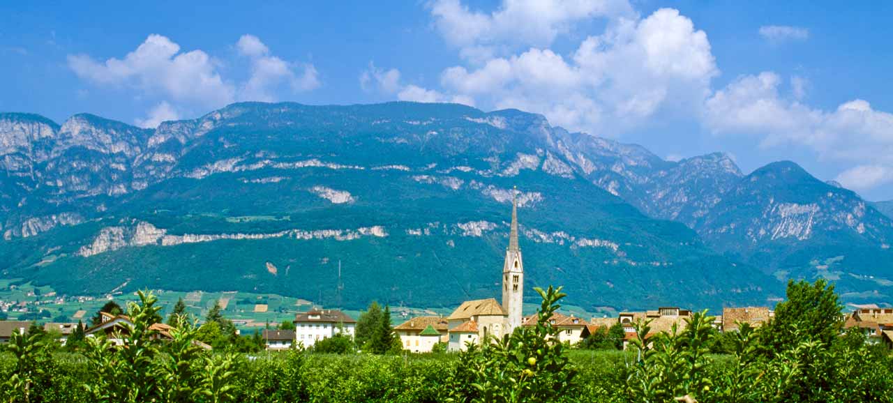 La città di Egna in lontananza e le montagne sullo sfondo