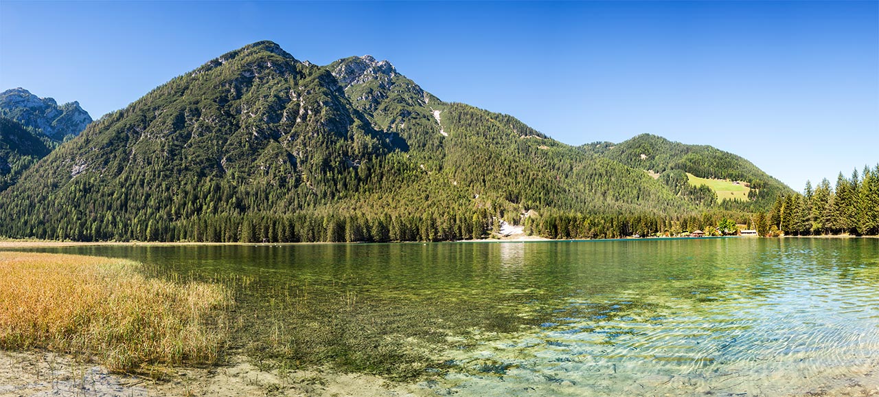 Il lago di Dobbiaco circondato dalle montagne