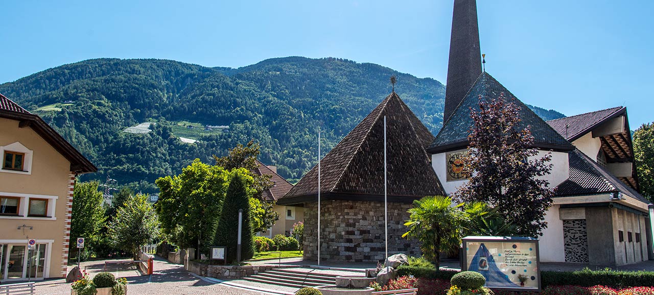 The church of Lagundo with the typical walls of stone and the modern bell tower