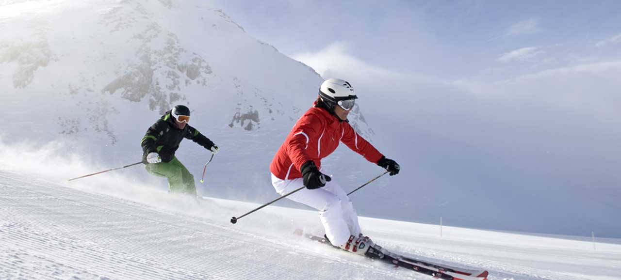 Due persone intente a sciare sulle piste dell'Alto Adige