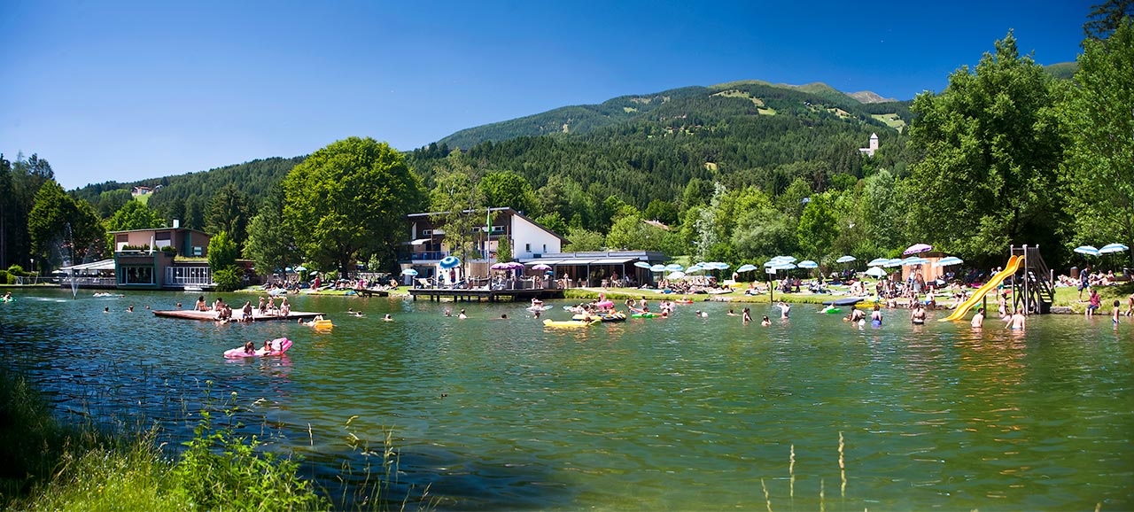 Badende im türkisen Wasser des Issinger Weiher an einem sonnigen Tag