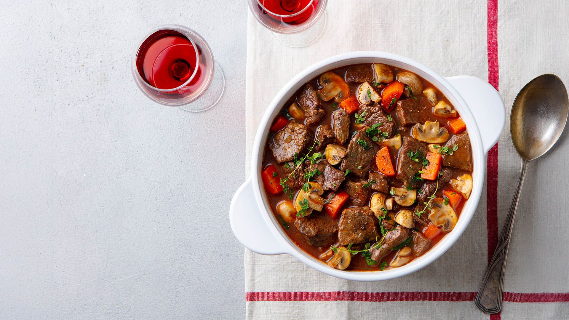 Rinderragout mit Gemüse, serviert mit Rotwein
