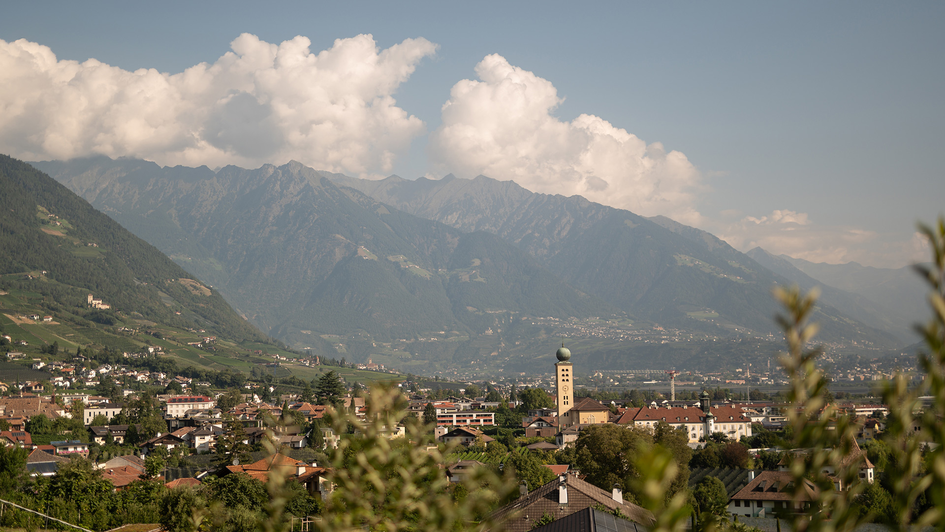 Panoramic view of Lana in South Tyrol, with houses, bell tower, and mountains in the background