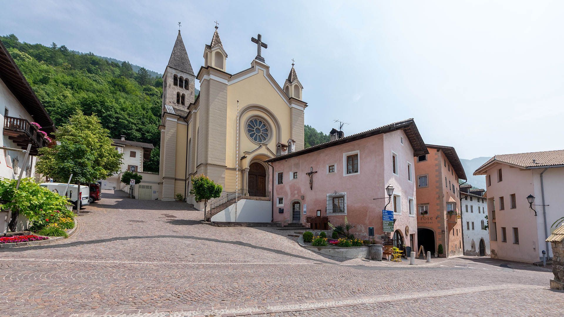 Village square with church and historic houses at the edge of the forest