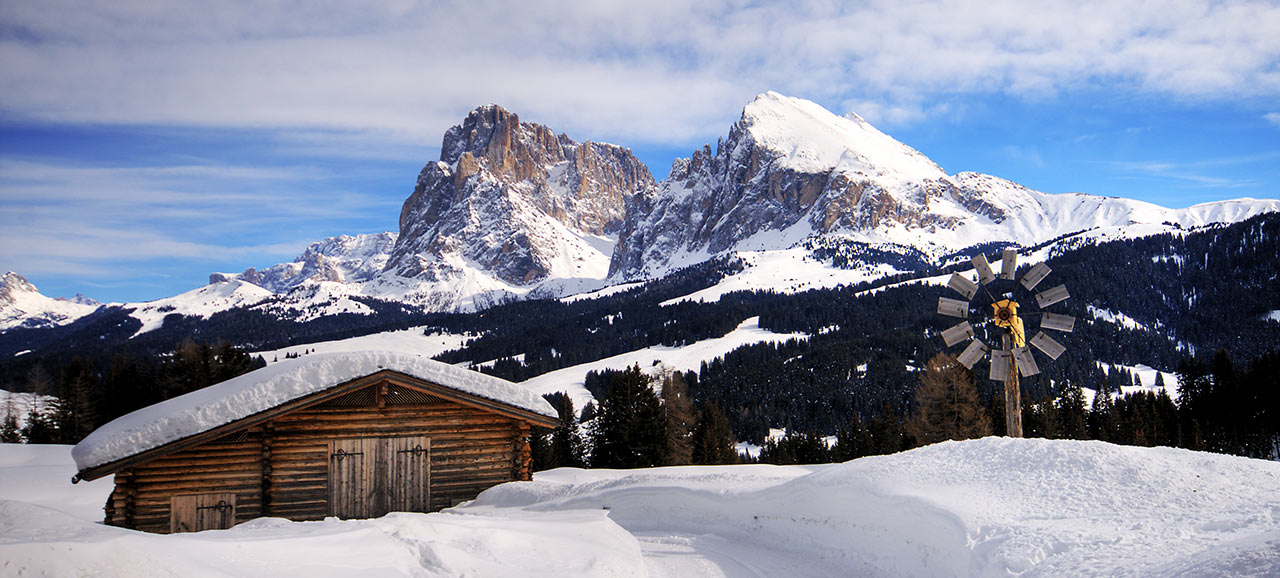 Einsame Holzhütte mitten in einer weißen Schneelandschaft an der Seiser Alm