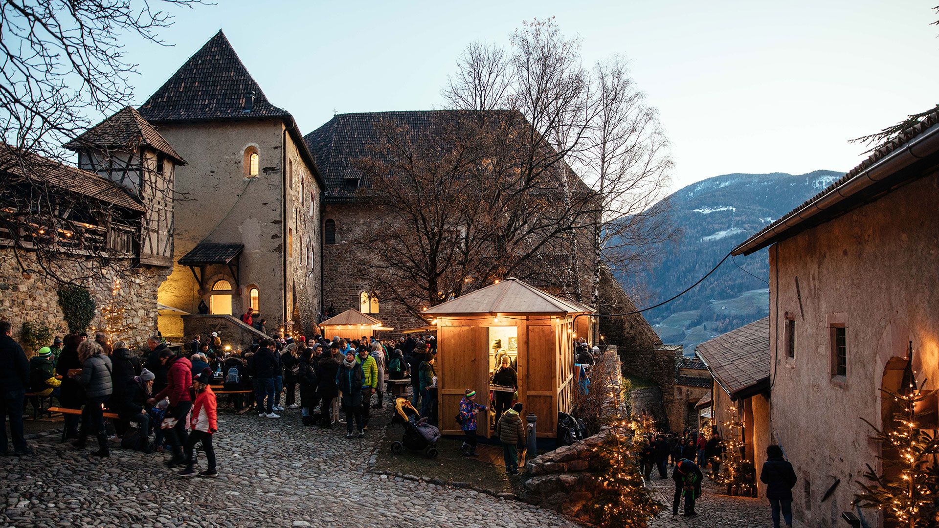 Castel Tirolo con la sua torre massiccia tra gli alberi, sopra la Val d’Adige
